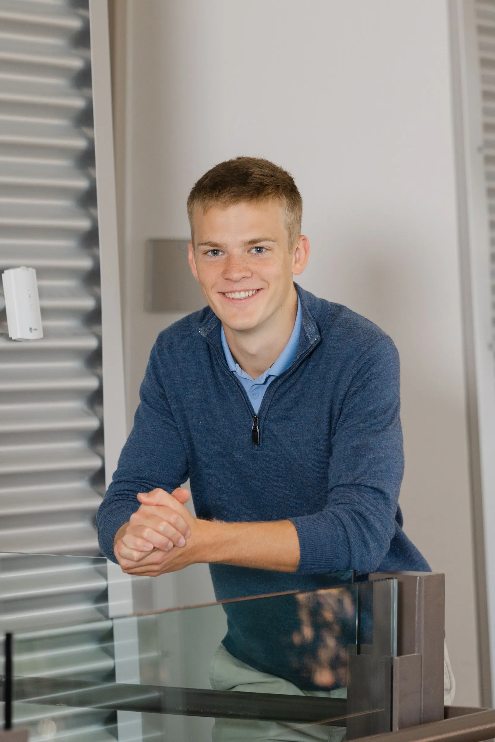 Jared Swift leaning on a glass railing and smiling