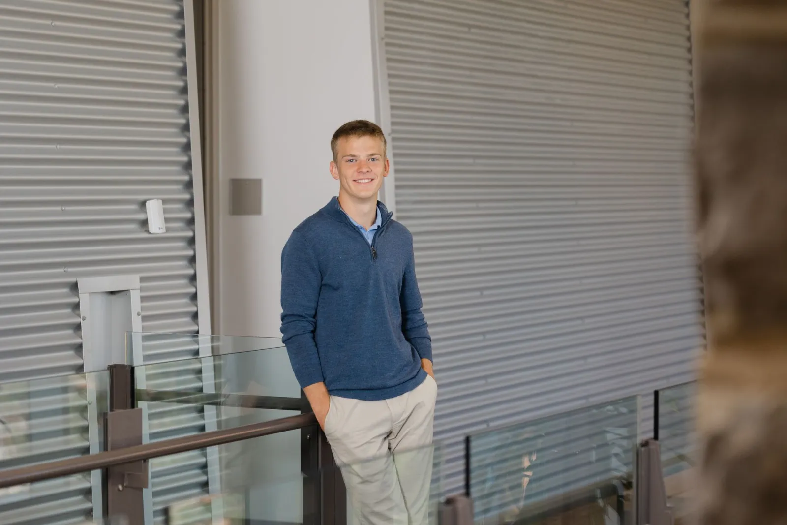 Jared Swift standing by a glass railing inside a modern building